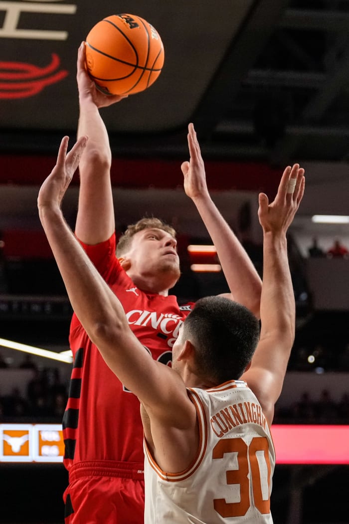 Cincinnati Bearcats forward Viktor Lakhin (30) rises above Texas Longhorns forward Brock Cunningham (30) in the first half of the NCAA Big 12 basketball game between the Cincinnati Bearcats and the Texas Longhorns at Fifth Third Arena in Cincinnati on Tuesday, Jan. 9, 2024.